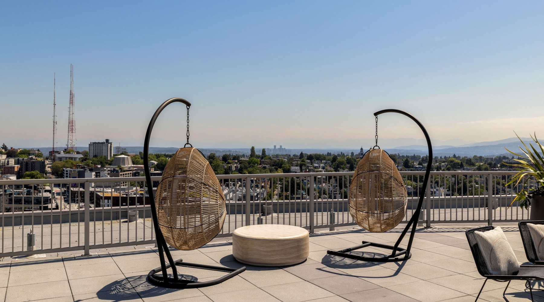 Rooftop with hanging chairs overlooking a city