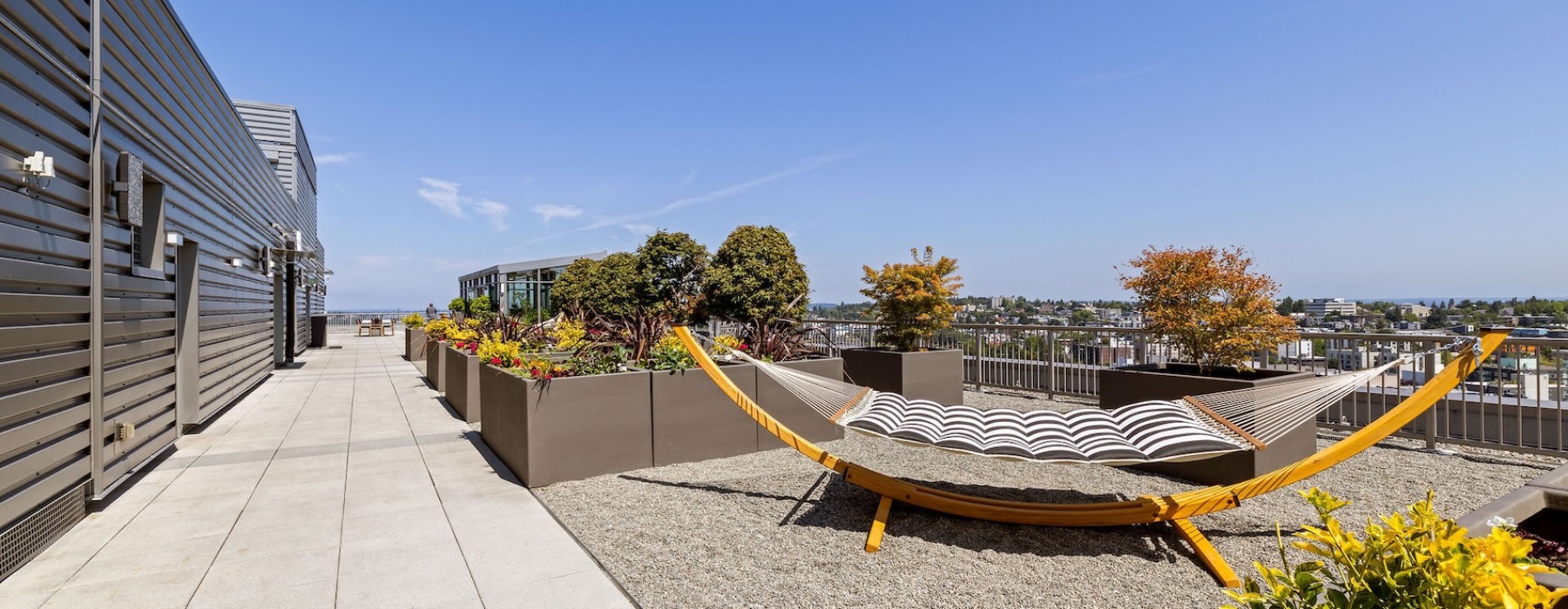 a hammock on a roof with plant boxes