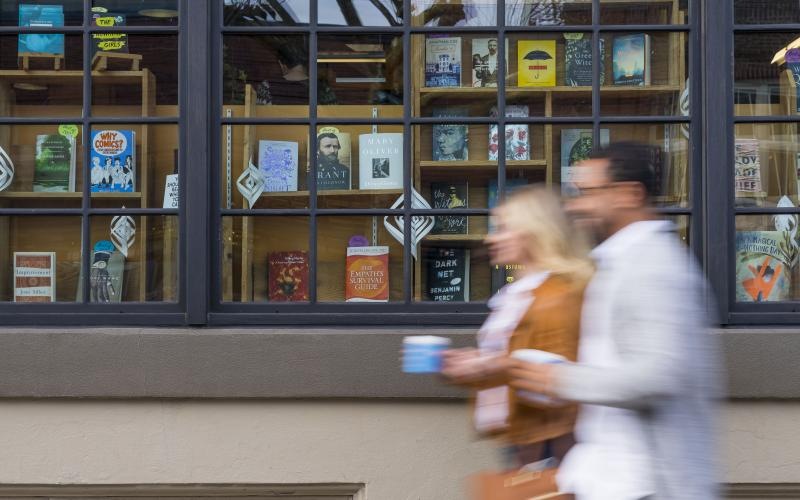 a man and woman walking in front of a store