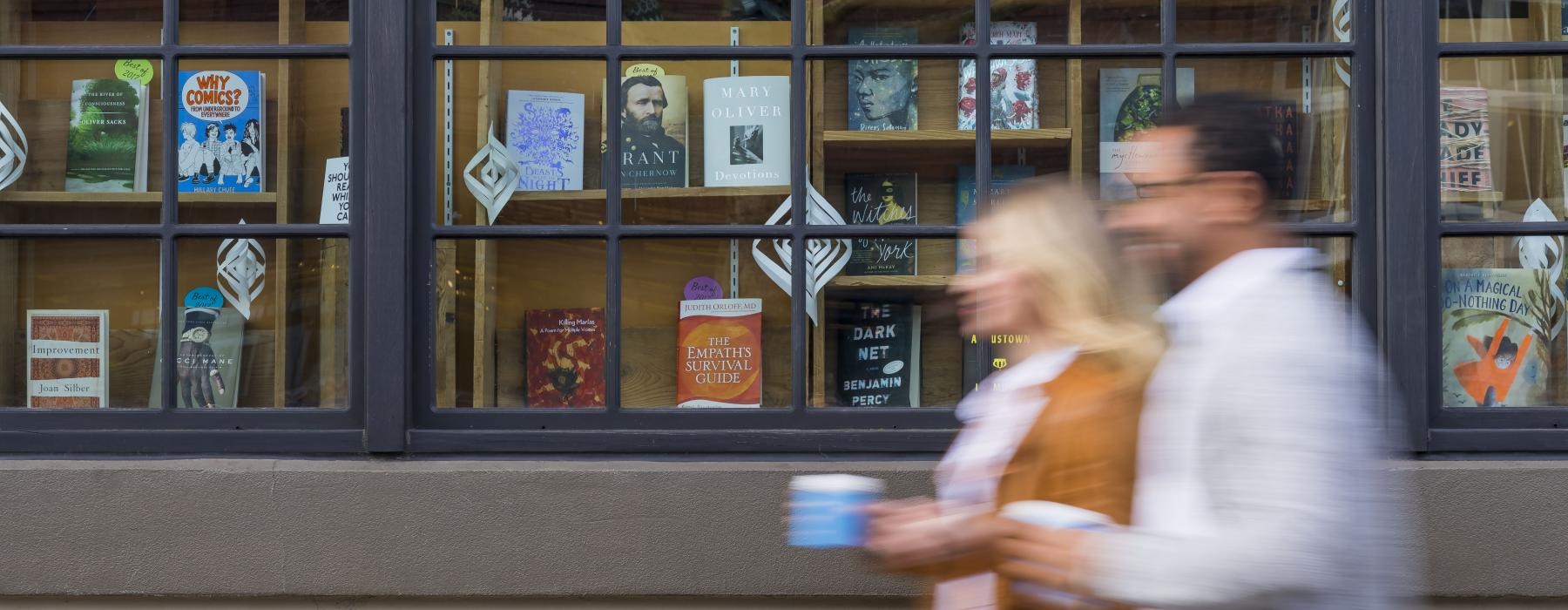 a man and woman walking in front of a store