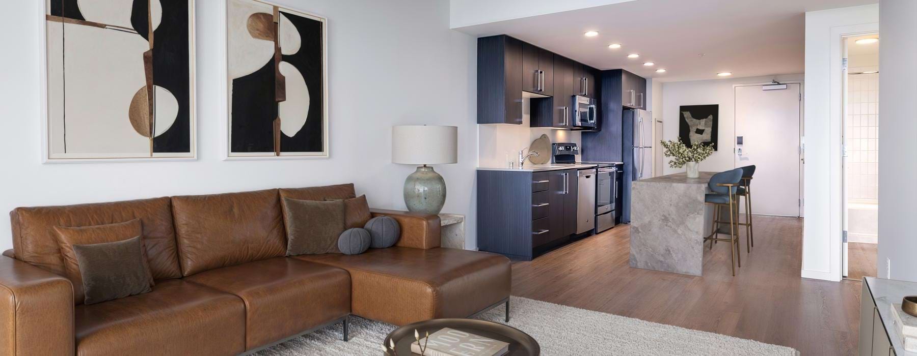 a living room with a couch coffee table and view of a kitchen